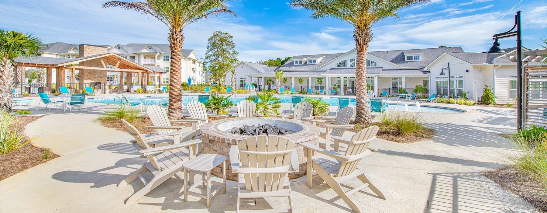 a poolside fire pit with lounge chairs